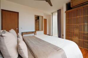 Un dormitorio con cama, armario de madera, espejo y ventilador de techo.