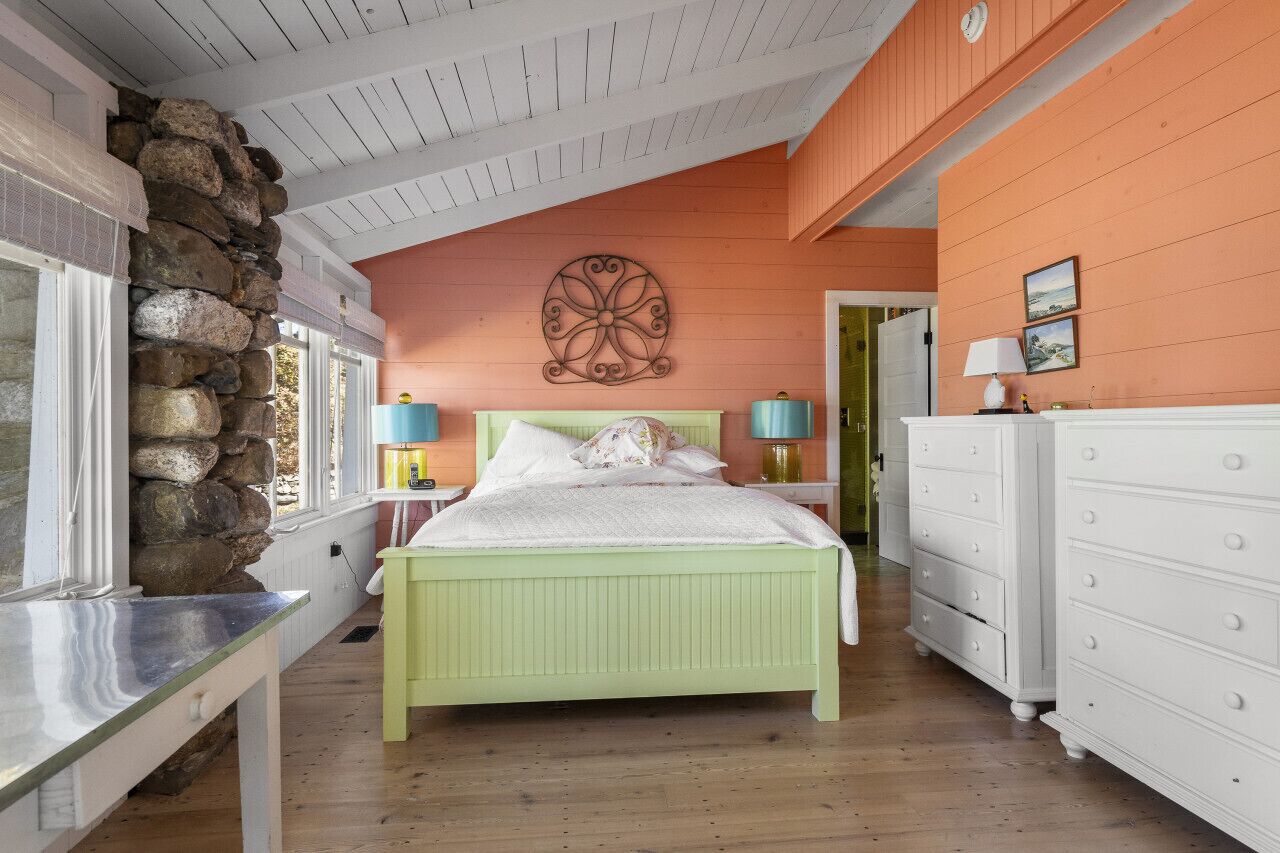 First floor bedroom with queen-sized bed, ensuite bathroom, and water views