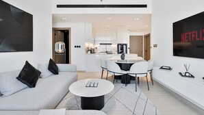 Una sala de estar moderna con sofá, mesa de centro y un comedor con sillas y mesa.