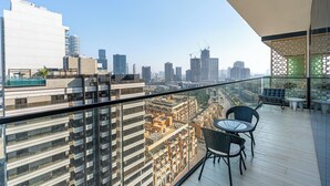 Un balcón con vista a un paisaje urbano, con edificios modernos y cielo despejado.