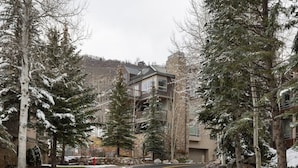 A snow-covered road with a modern building featuring balconies and large windows. - Cascade Village - Westhaven Condo Sleeps 24 (Vail)