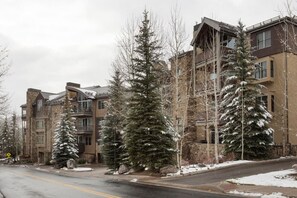 Un immeuble à plusieurs étages, doté d’une façade en pierre et de nombreux balcons.