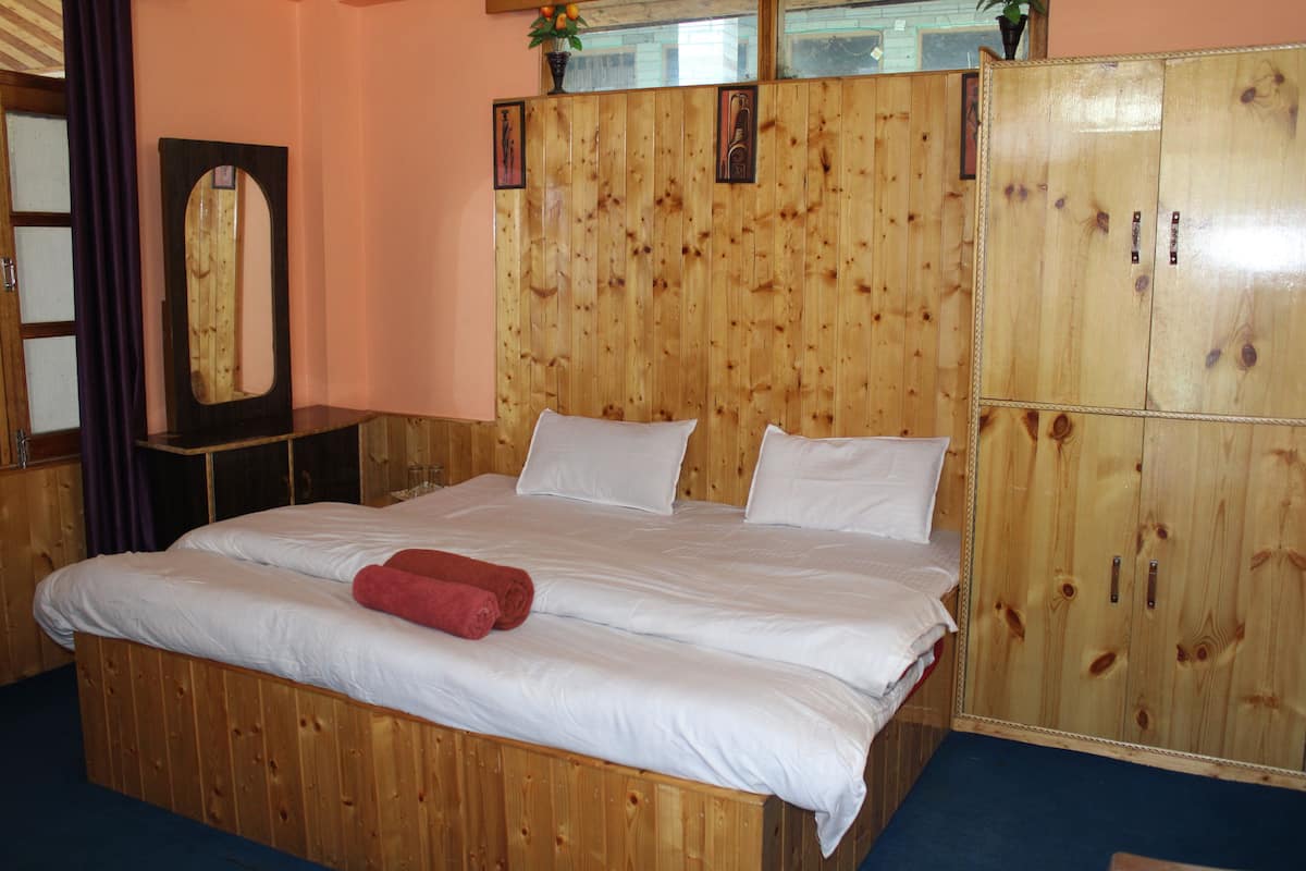 Una habitación con paneles de madera, una cama, un espejo y un armario.