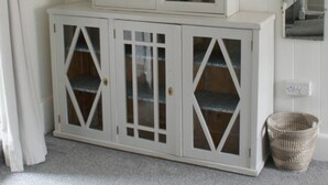 A white cabinet with glass doors and a radio on top. - Dinham Cottage - Cornish Cottage in Boscastle Harbour (Boscastle)