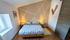 Una camera da letto moderna con un letto di legno, due comodini con lampade, una finestra e un motivo geometrico sulla parete.