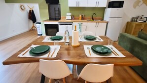 Una cucina moderna con mobili bianchi, una cappa aspirante nera e un forno a microonde.