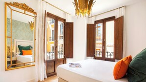 Ein Hotelzimmer mit einem großen Bett, einem Spiegel und Blick auf den Balkon.