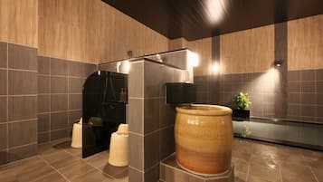 Une salle de bain moderne avec une grande baignoire en céramique, un espace douche et une plante en pot.