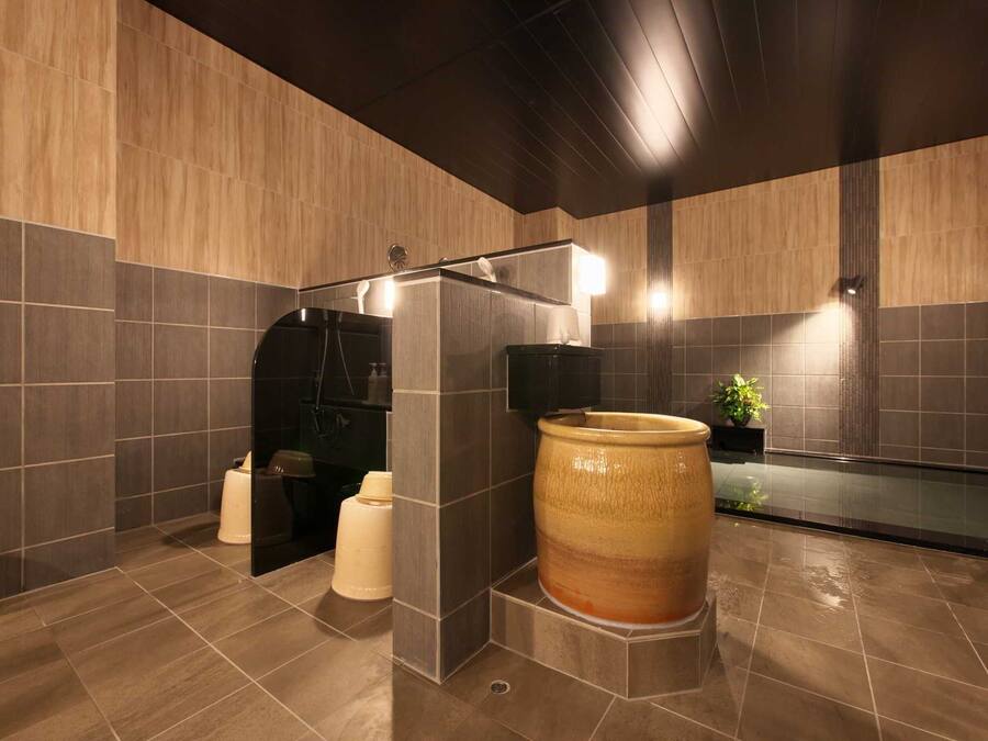 Une salle de bain moderne avec une grande baignoire en céramique, un espace douche et une plante en pot.