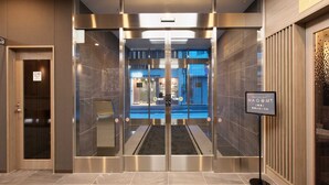 A modern elevator entrance with a glass door, a sign for Nagomi Restaurant, and a tiled floor. - Hotel Route Inn Hiratsuka Eki Kitaguchi (Hiratsuka)