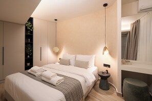 A modern bedroom with a large bed, bedside tables, a built-in shelf with plants, and a hanging light fixture.