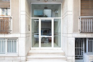 A building entrance with a glass door, steps leading up to it, and a number '40' on the wall.