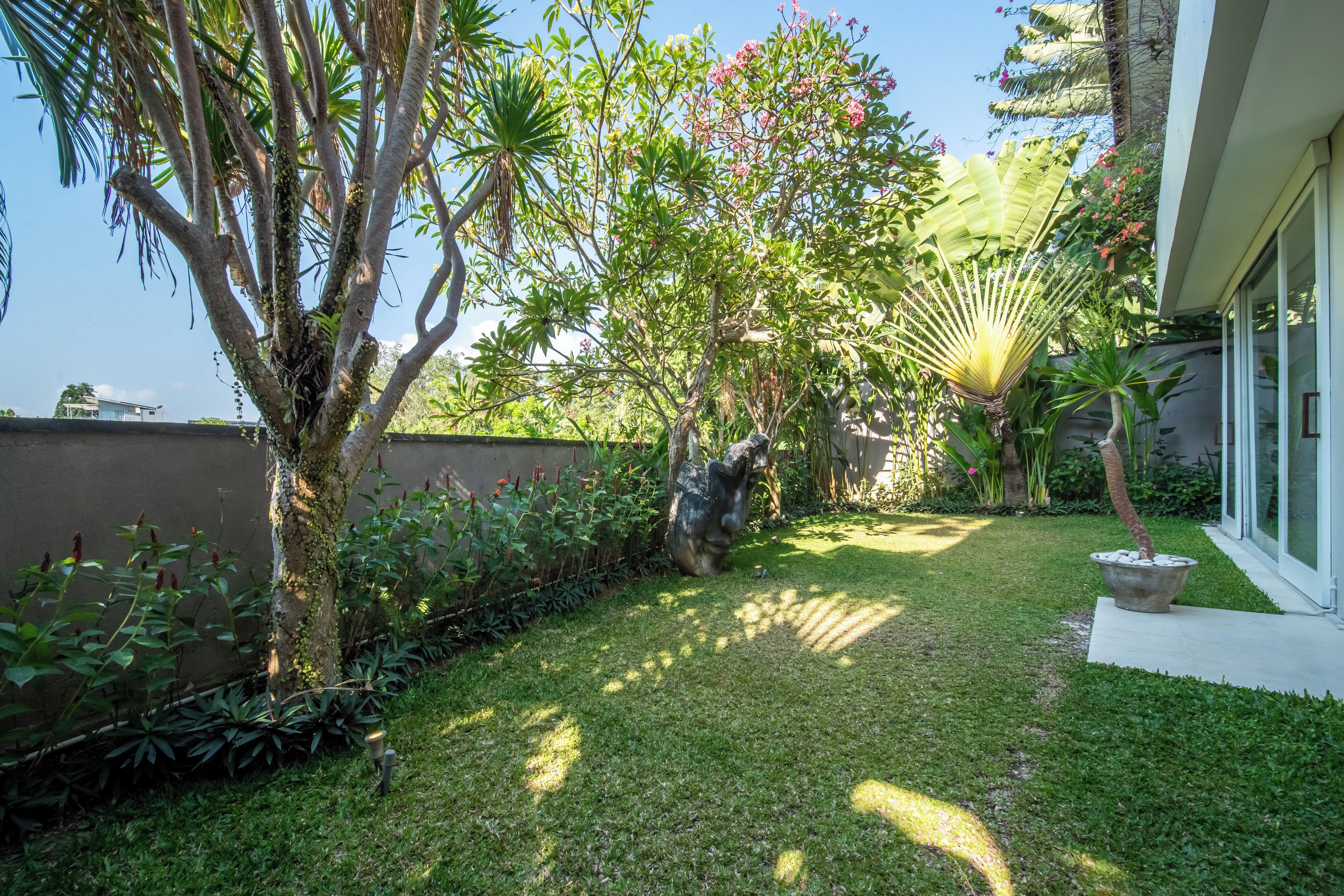 A well-maintained garden with a variety of plants and a statue.