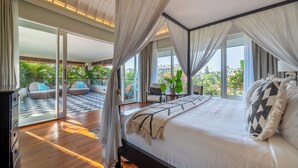 A bedroom with a large bed, a view of the outdoors, and a balcony with seating. - Villa Sunsara 2 (Canggu)
