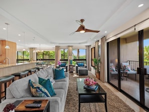 A spacious living area with a sofa, coffee table, and a dining area with chairs and a table.