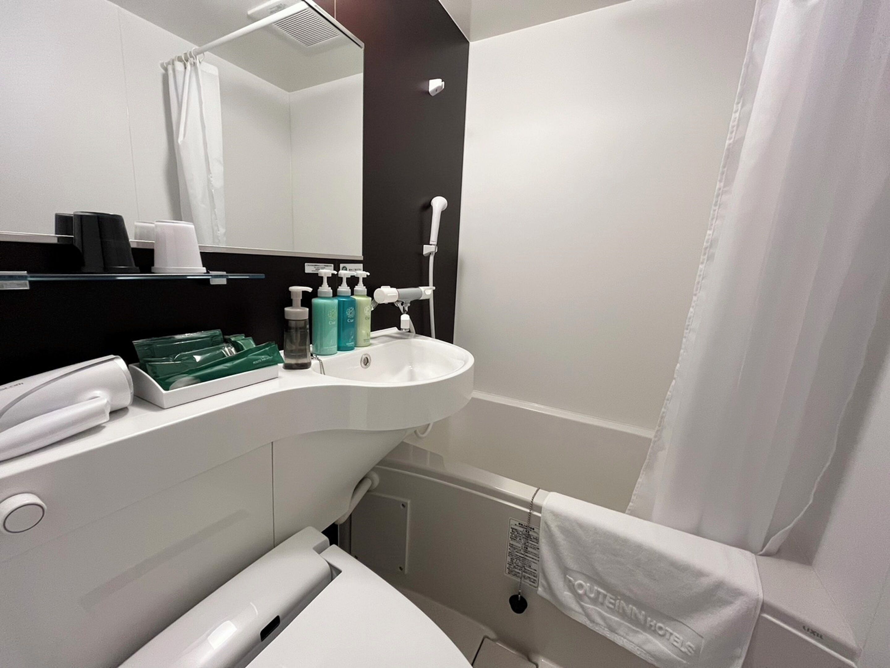 Un baño moderno con un lavabo blanco, un espejo y artículos de aseo.
