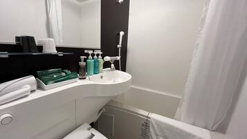 Un baño moderno con un lavabo blanco, un espejo y artículos de aseo.