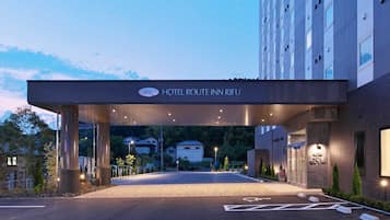 A hotel entrance with a covered walkway, a sign reading "HOTEL ROUTE INN RIFU", and a parking area with marked spaces.