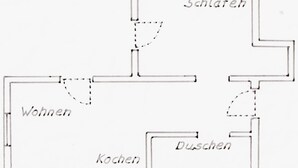 A floor plan with labeled rooms: Wohnen, Küche, Schlafen, and Duschen. - Small, fine & rural (Pronstorf)