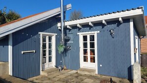 A blue building with a metal roof, a door, and a window. - Small, fine & rural (Pronstorf)