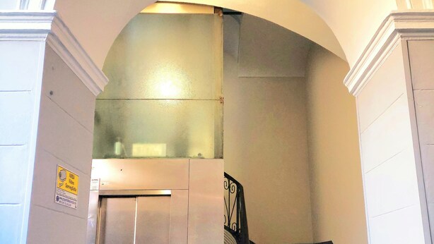 A staircase with a metal elevator door and a handrail. - Cozy apartment for families and groups of friends 5 minutes from downtown (Torino)