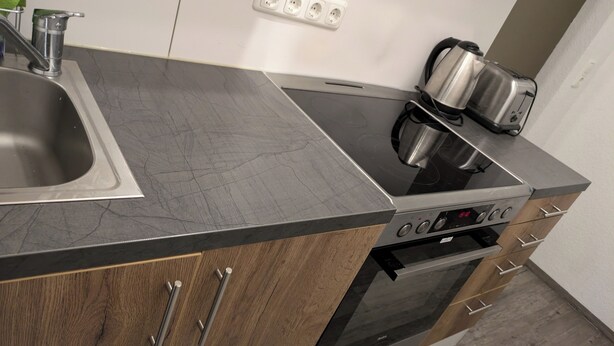 Una cocina moderna con estufa, horno y lavaplatos integrados.