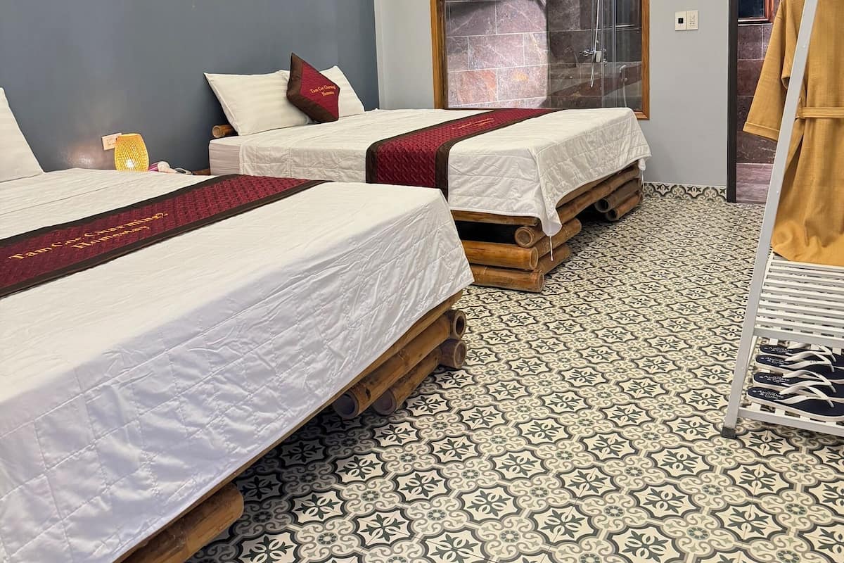 Ein Hotelzimmer mit zwei Betten, einer Dusche und einem gemusterten Boden.