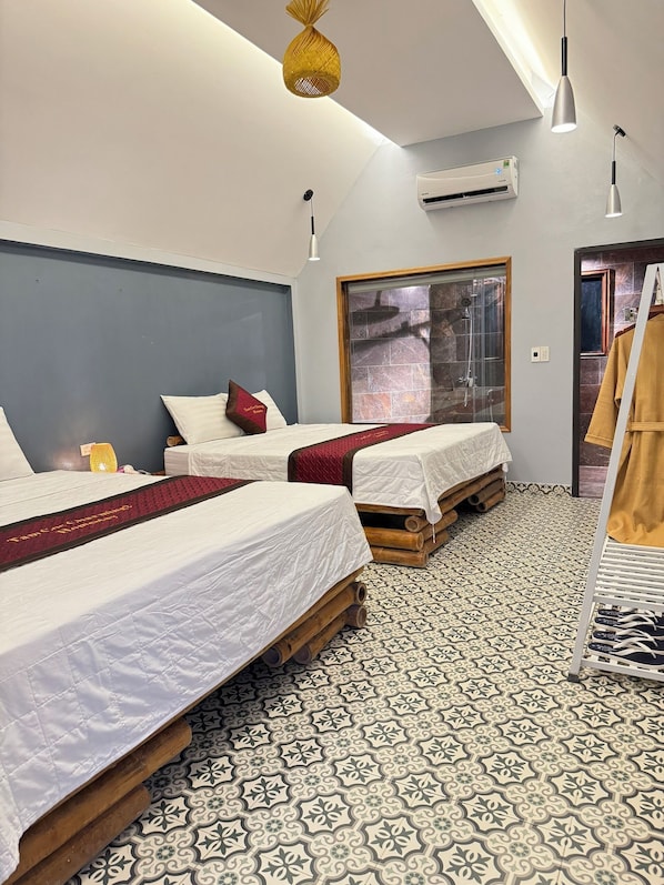 Une chambre d’hôtel avec deux lits, une douche et un sol à motifs.