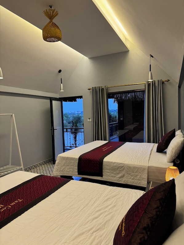 A modern hotel room with two beds, a balcony with a view, and a unique hanging light fixture. - Tam Coc Golden Fields Homestay (Nam Hoa Lu)