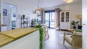 A modern kitchen with a wooden countertop, a dining area with a table and chairs, and a view through a large window. - A&N atico dimo terraza del Mar (Algarrobo Costa)