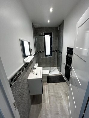 Ein modernes Badezimmer mit Dusche, Toilette und Waschbecken.