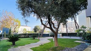 Ein Innenhof mit Baum, Weg und kleinem Garten.