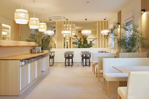 A modern restaurant with a wooden counter, multiple tables, and hanging lights. - Pension Pakeleku (Urnieta)