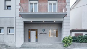 Un bâtiment à la façade moderne, doté d’un balcon avec des balustrades en métal et d’une enseigne sur laquelle on peut lire « pakeleku ».