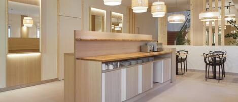 Una cocina moderna con encimeras de madera, un lavamanos integrado e iluminación colgante.