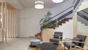 Un intérieur moderne avec un escalier, un coin salon et une plante.