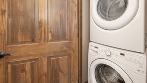 A wooden door and a stacked washer and dryer.