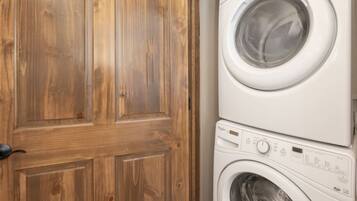 A wooden door and a stacked washer and dryer.