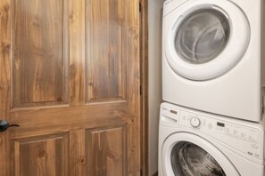 A wooden door and a stacked washer and dryer. - Hot Tub | Mountain Views | Steps to Trails (Winter Park)