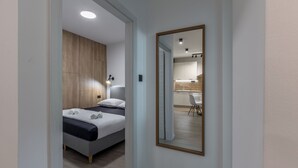 Un dormitorio moderno con cama, mesita de noche y espejo.