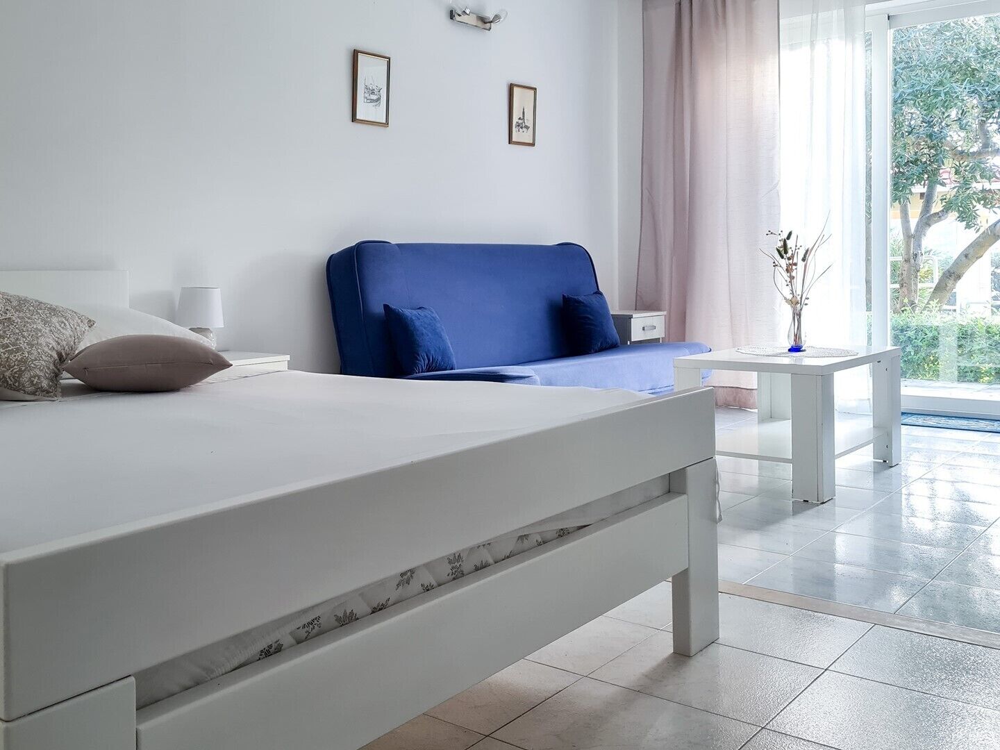 A modern bedroom with a large bed, a bedside table, and a view of the outdoors.