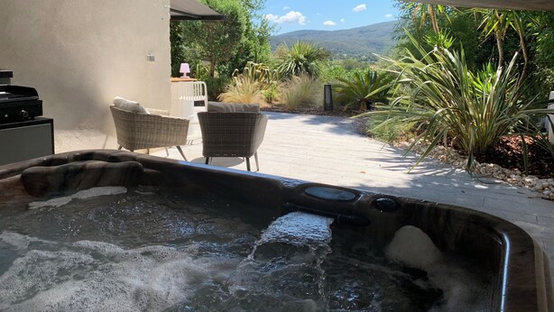 A hot tub area with a view of a garden and mountains in the background. - Seaside gîte 2 to 4 pers. (Vidauban)