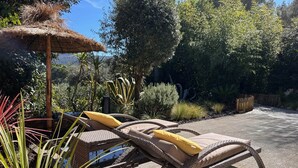 A patio with wicker lounge chairs and a thatched umbrella. - Seaside gîte 2 to 4 pers. (Vidauban)