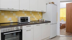 A compact kitchen with white cabinets, a microwave, an oven, and a refrigerator. - 2-Bedroom Apartment Mokalo with amazing sea view! (Orebic)