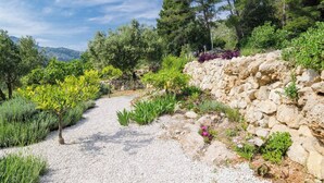A garden pathway with gravel, surrounded by various plants and a stone wall. - 2-Bedroom Apartment Mokalo with amazing sea view! (Orebic)
