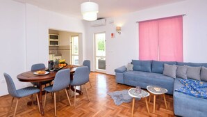 A compact living space with a dining area, a sofa, and a small kitchen.