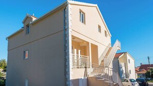 A two-story building with a balcony and a staircase leading to the upper floor. - Beautiful 1-Bedroom Apartment Sandra (Orebic)