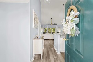 A hallway with a teal door, a white bench, and a ceiling fan. - Great 3 BR retreat at Village @the Glen (Little River)