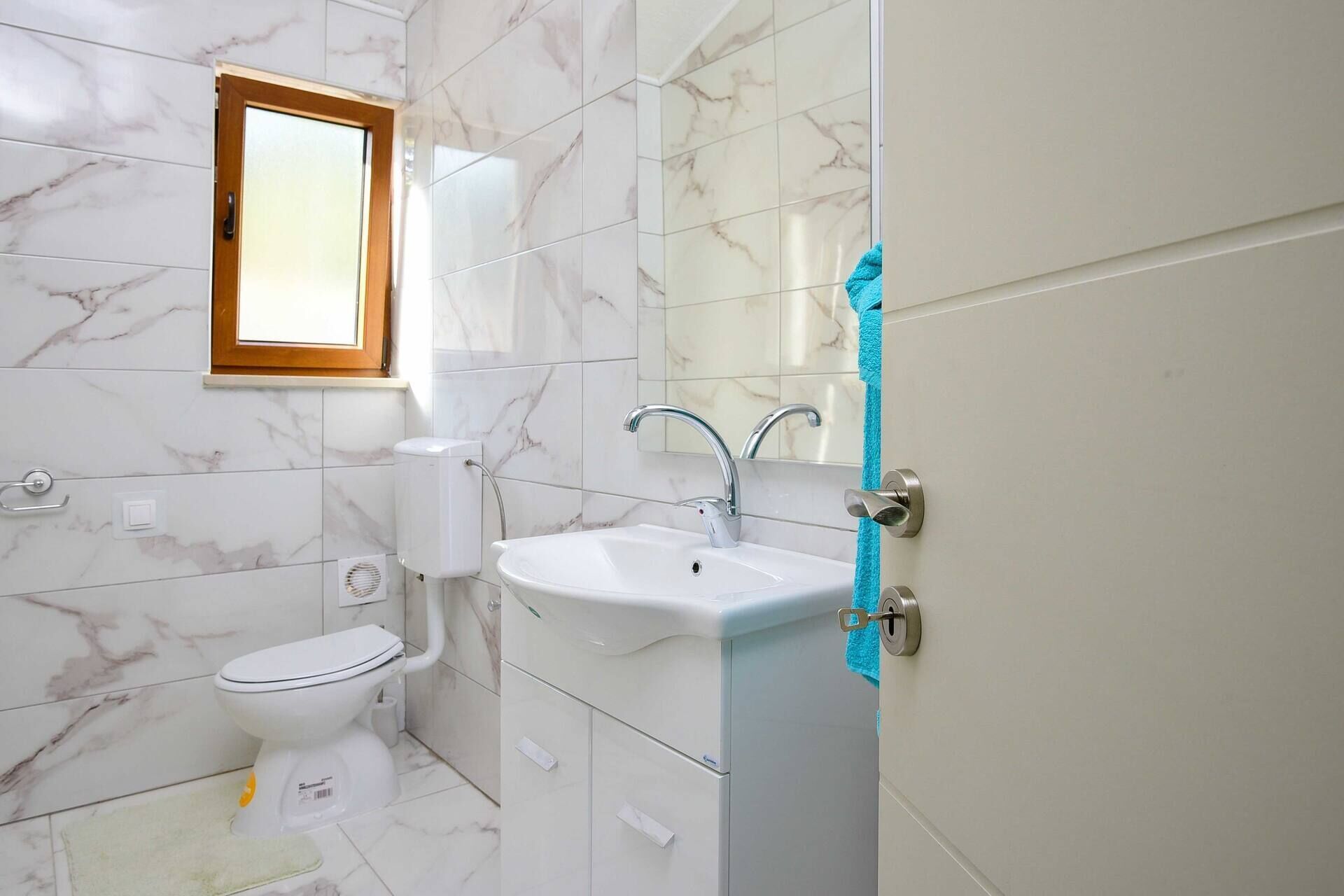 Ein Badezimmer mit Toilette, Waschbecken und Spiegel.