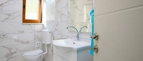 Ein Badezimmer mit Toilette, Waschbecken und Spiegel.